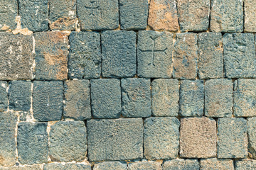 closeup of a stone wall of an Armenian temple with crosses