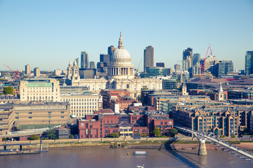 St. Paul's cathedral and City of London view including river Thames and Millennium bridge in early morning.