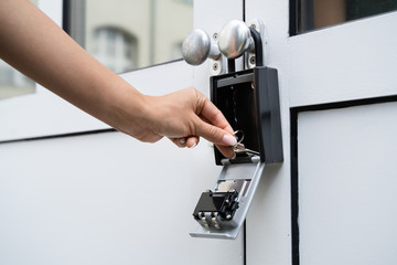 Woman Using Key Safe To Retrieve Keys