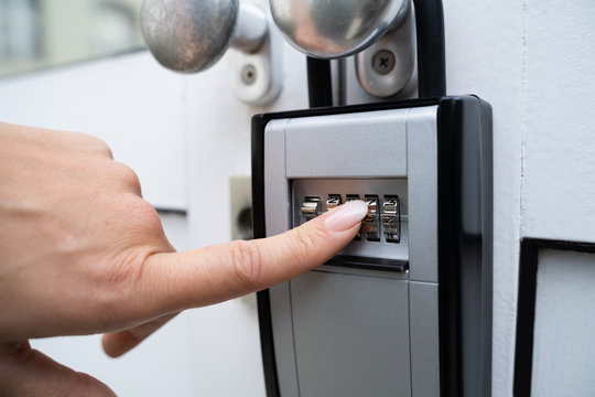 Woman Using Key Safe To Retrieve Keys