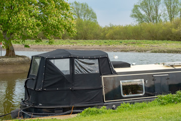 Moored narrow boat seen on an inland waterway during late spring.  One of a number of narrow boats used for hire and also private owners.