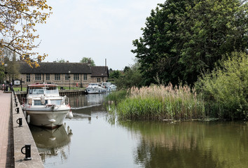 Obraz premium Large private houses seen next to a large, inland river together with small boats used for transport along the fresh water river.