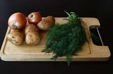 Fresh vegetables on wooden cutting board for cooking.