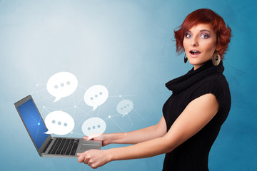 Woman holding laptop with a few speech bubble symbols