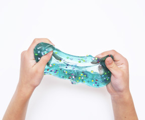 Blue slime in child hands on white background.