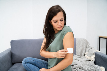 Naklejka premium Woman Applying Patch On Her Arm