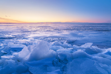 Obraz premium misty dawn on a frozen river / sun breaks through morning fine snow