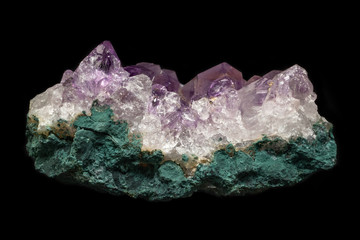 Rock of natural violet amethyst mineral from Brazil isolated on a pure black background.