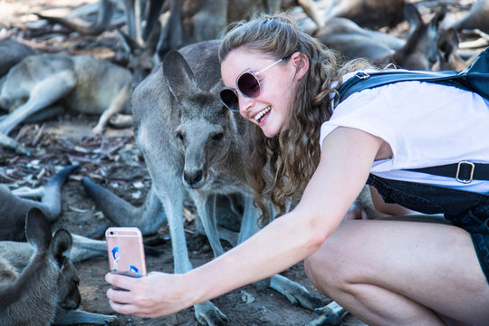 Young woman takes selfie with kangaroo