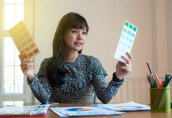 Asian girl designers choose the color scheme for her work.