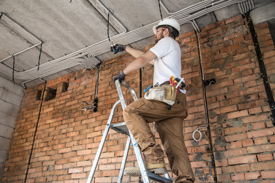 Electrician with tools, working on a construction site. Repair and handyman concept.