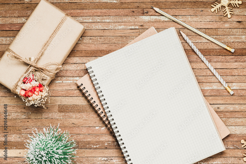 Aufkleber top view of blank notebook on wood background with giftbox and christmas ornaments decorations. mock