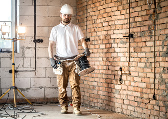 Electrician with tools, working on a construction site. Repair and handyman concept.