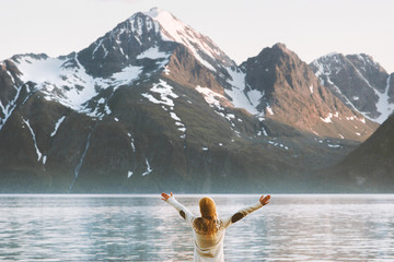Traveler woman raised hands enjoying mountains Lyngen Alps view travel adventure vacations in Norway healthy lifestyle