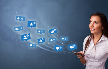 Young person using phone with flying social media icons around
