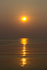 Fototapeta na wymiar The blue sea in the morning with the rising sun