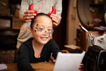 母親にハロウィンの仮装を手伝ってもらう女の子