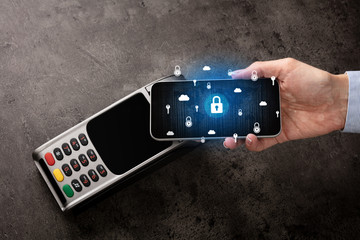 Hand paying with cellphone on POS, secure payment concept