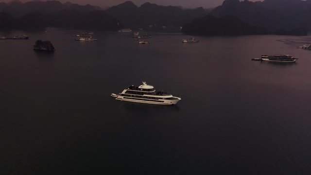 Aerial drone footage of Ha Long Bay and ships in the bay at Sunrise in October 2019