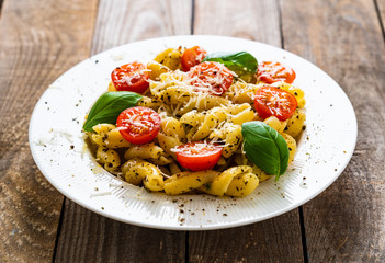 Pasta with cherry tomatoes and cheese on wooden table