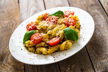 Pasta with cherry tomatoes and cheese on wooden table