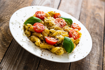 Pasta with cherry tomatoes and cheese on wooden table