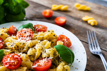 Pasta with cherry tomatoes and cheese on wooden table