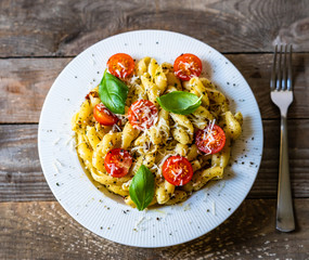 Pasta with cherry tomatoes and cheese on wooden table