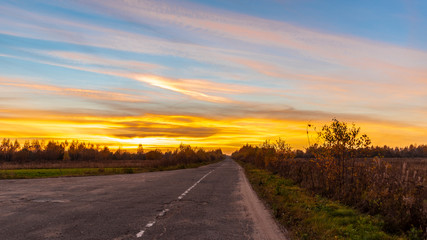 Suburban road goes into the distance at sunset