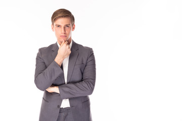 Portrait handsome, confident young businessman in classic gray suit, keep hand touching his chin. Good looking guy planning, thinking how to improve his skills  and developing his company of business
