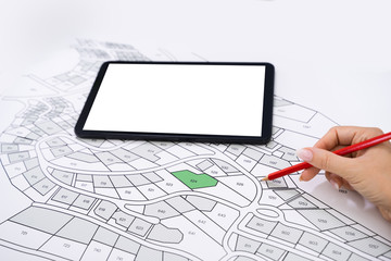 Human Hand Holding Pencil Over Cadastre Map