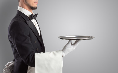 Waiter serving with white gloves and steel tray in an empty space