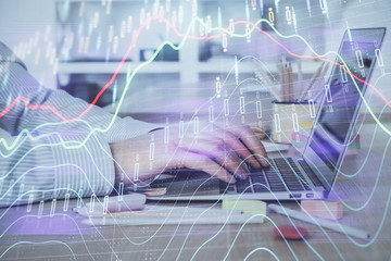 Double exposure of stock market graph with man working on laptop on background. Concept of financial analysis.