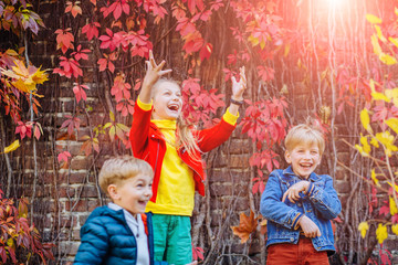 three cute siblings together outside with bright colored background