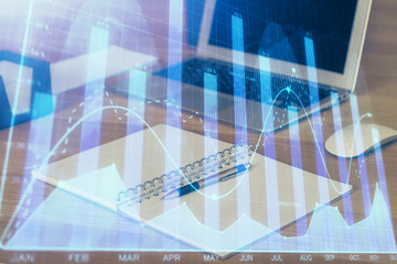 Double exposure of graph and financial info and work space with computer background. Concept of international online trading.