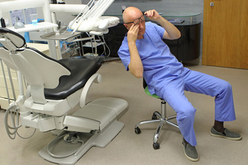 Tired mature dentist with eyes problem. Having short break for regeneration after long working...