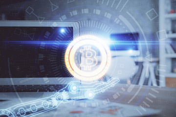 Multi exposure of blockchain theme hologram and table with computer background. Concept of bitcoin crypto currency.