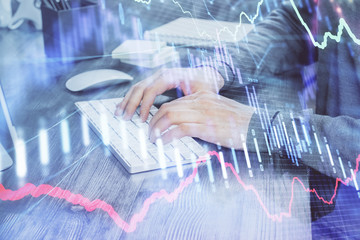 Double exposure of businessman's hands with laptop and stock market graph background. Concept of...