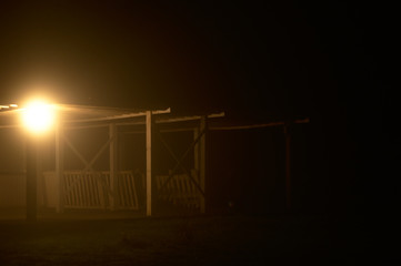 Old wooden construction at night in the fog with a single light. Poznań, Poland