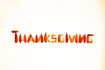 Happy Thanksgiving text on a white background with autumn leaves