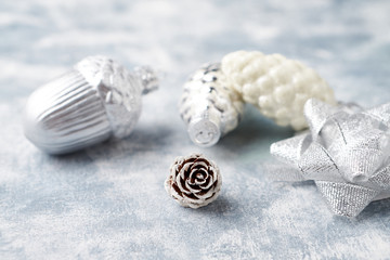 Naklejka premium Pine cone and silver Christmas baubles. Christmas decoration on bright wooden background. Close up. 