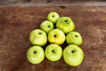 a pile of fresh juicy green apples on an old wooden surface