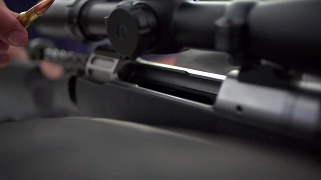 Loading a  bullet in a gun on a rifle.