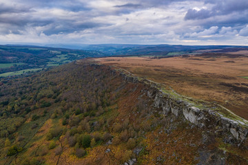 Fototapeta na wymiar Stunning Autumn Fall landscape aerial drone image of Crubar Edge in Peak District at sunset with lovely evening light glow