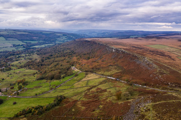 Stunning Autumn Fall landscape aerial drone image of Crubar Edge in Peak District at sunset with lovely evening light glow