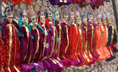 Colorful Rajasthani puppets hanging in the shop of Jaisalmer City Palace in India