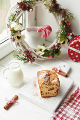 Christmas cake, milk, cinnamon on a white background by the window