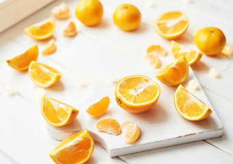 Christmas oranges and tangerines on a white background by the window