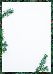 copy space, blank paper on wooden table with fir green fir,  branches as a frame, christmas decoration, winter, background