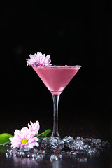 Pink cocktail on a black background in a high glass. Copy of space.